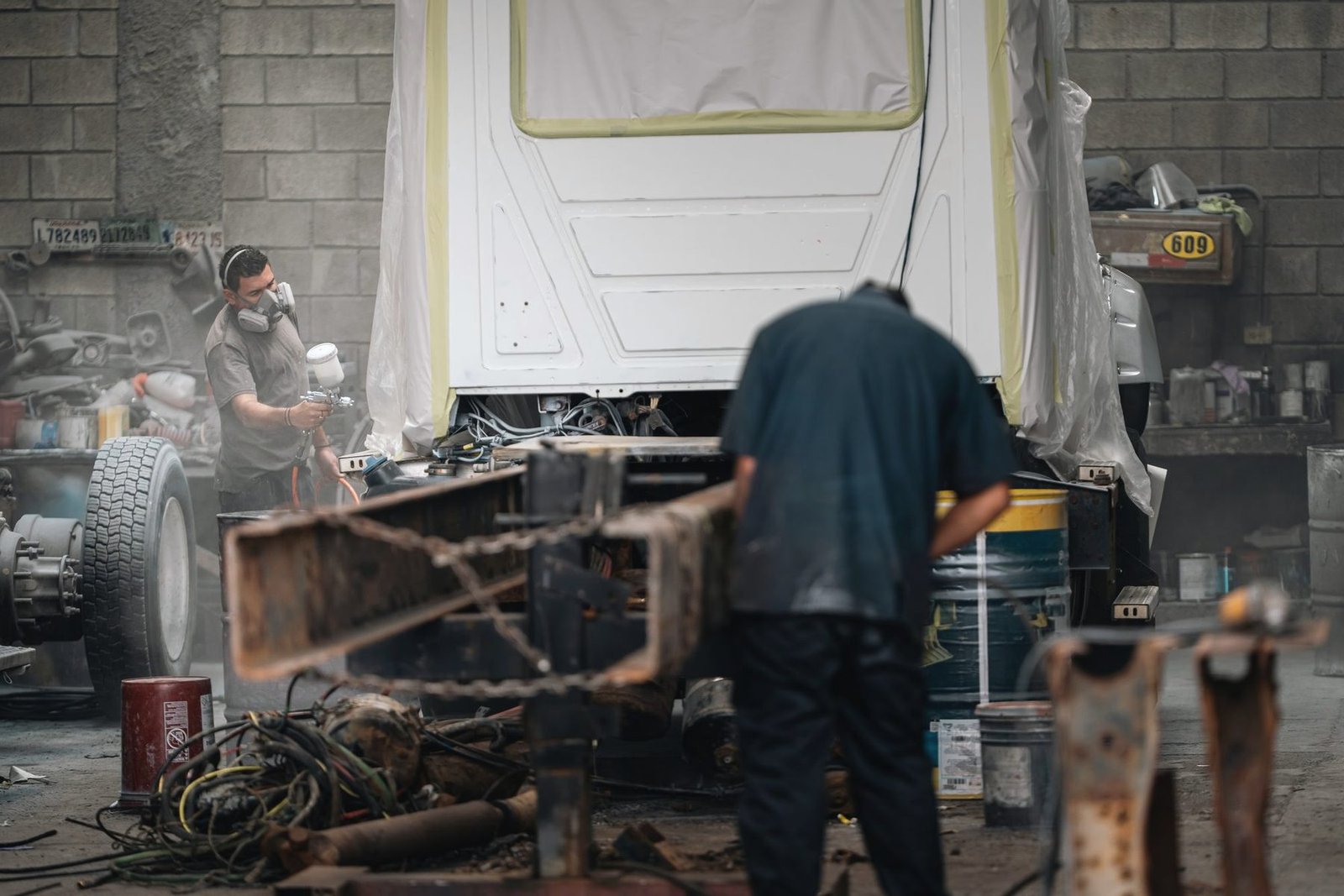 A stripped frame on stands in a crowded repair bay